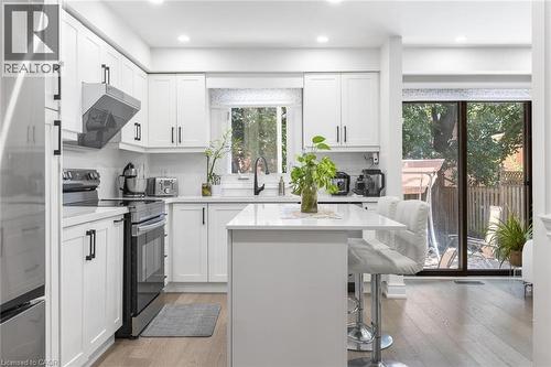 Kitchen with stainless steel appliances, white cabinets, light wood finished floors, and recessed lighting - 1118 Avondale Drive, Oakville, ON 