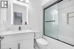 Bathroom with shower / bath combination with glass door and vanity - 