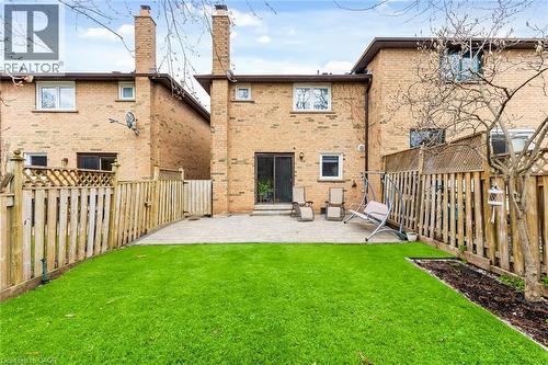 Rear exterior featuring brick construction, a paved patio, and a manicured lawn area - 1118 Avondale Drive, Oakville, ON 
