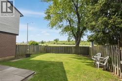 Expansive rear yard featuring green lawn space and mature trees - 