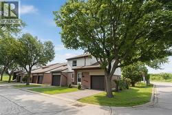 Brick and siding townhome featuring an integrated garage, a front entry with a small porch, and a paved driveway - 