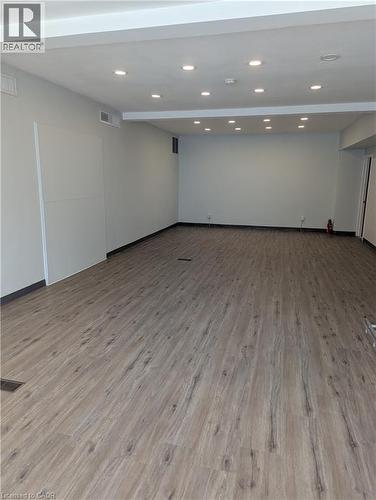 Spacious interior room featuring wood-finish flooring, recessed lighting, and light-toned wall paint - 499 Main Street E, Hamilton, ON 