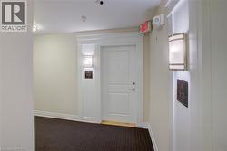 White paneled entry door framed by decorative trim and wall sconces - 