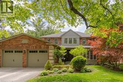 Brick and siding exterior featuring a two-car garage with transom windows - 
