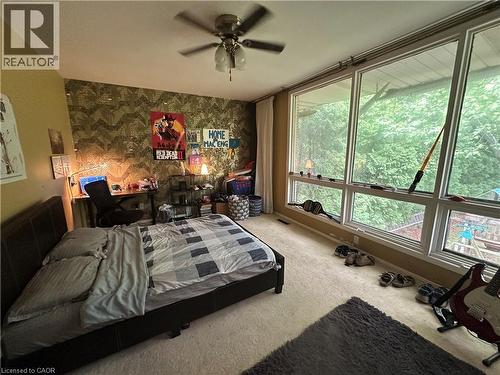 Spacious room featuring a full wall of floor-to-ceiling windows, soft wall-to-wall carpeting, and a ceiling fan - 11 Wilmont Court, Hamilton, ON 