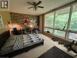 Spacious room featuring a full wall of floor-to-ceiling windows, soft wall-to-wall carpeting, and a ceiling fan - 