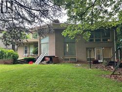 Brick exterior with multiple large windows and a rear patio - 