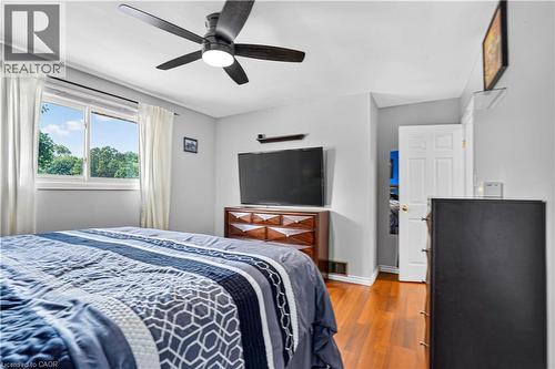 Bedroom with wood-finish flooring, a ceiling fan with integrated lighting, and a white-trimmed window - 234 Thunderbird Drive, Cambridge, ON - Indoor Photo Showing Bedroom