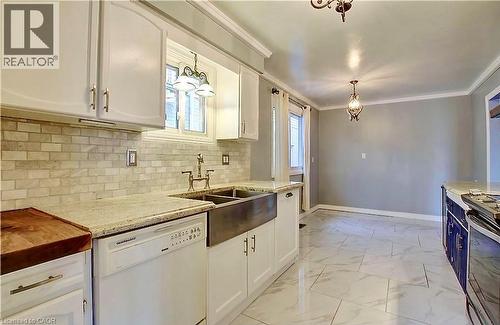 Kitchen featuring white cabinetry with brushed nickel hardware, light-toned granite-finish countertops, and a subway tile backsplash - 599 Upper Horning Road Unit# Main/Upper, Hamilton, ON 