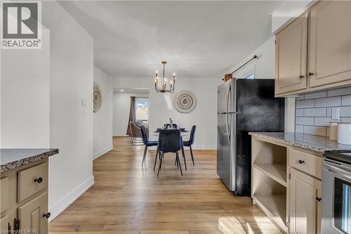 Kitchen area featuring light-toned cabinetry, granite-style countertops, and a subway tile backsplash - 127 Acorn Crescent, London, ON 