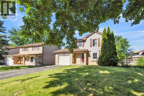 Two-story residence featuring a two-car garage, red front door, and white shutter accents - 127 Acorn Crescent, London, ON 