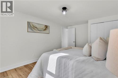 Bedroom featuring light wood-finish flooring, white walls, and a contemporary flush-mount ceiling light fixture - 127 Acorn Crescent, London, ON 