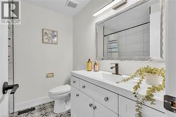 Bathroom featuring a white vanity with integrated sink, bronze-finish faucet, and coordinating hardware - 