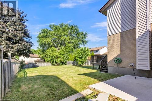 Expansive backyard featuring a manicured lawn, established trees, and a wooden privacy fence - 127 Acorn Crescent, London, ON 
