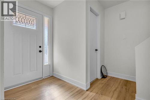 Entryway featuring a white paneled door with leaded glass transom, sidelight, and matte black hardware - 127 Acorn Crescent, London, ON 