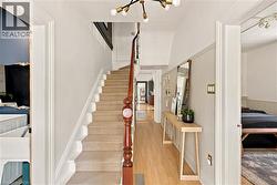 Central staircase featuring a wood banister and carpeted treads - 