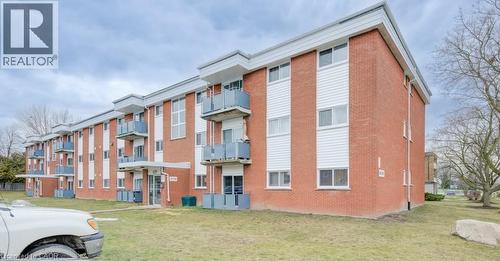 Multi-story residential building featuring red brick and white horizontal siding - 529 Parkside Drive Unit# 7, Waterloo, ON 