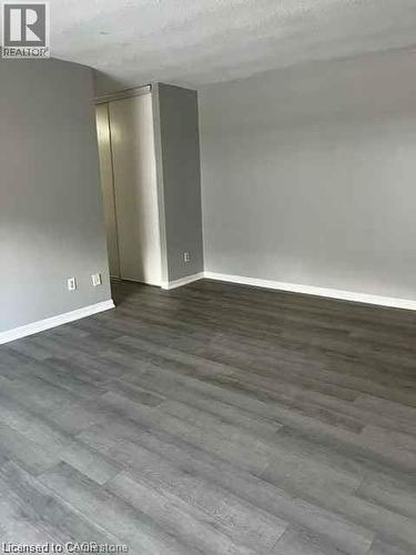Gray wood-finish flooring complemented by white baseboards and light gray walls - 529 Parkside Drive Unit# 7, Waterloo, ON 