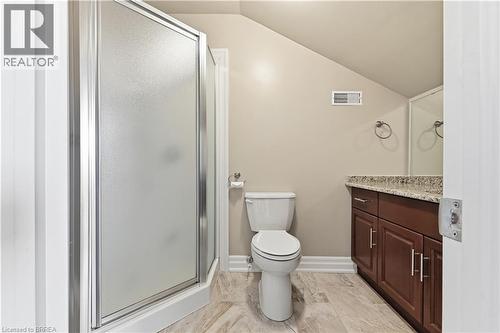 Bathroom featuring a corner shower with frosted glass enclosure, a white commode, and a dark wood vanity with a light-toned granite countertop - 29 Archdeacon Clark Trail, Hamilton, ON 