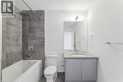 Contemporary bathroom featuring a tub/shower combination with dark gray tiled surround and a rainfall showerhead - 