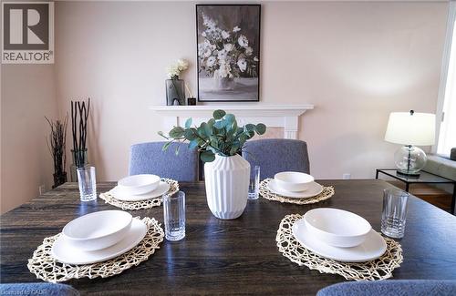 Dining area featuring a dark wood-finish table and upholstered chairs - 566 Avignon Place, Waterloo, ON 