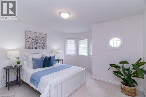 Recessed bay window area with three windows featuring blinds, octagonal decorative window, and light-colored wall-to-wall carpeting - 566 Avignon Place, Waterloo, ON 