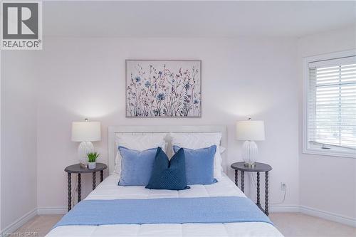Bedroom featuring a white headboard, soft wall color, and a window with blinds - 566 Avignon Place, Waterloo, ON 