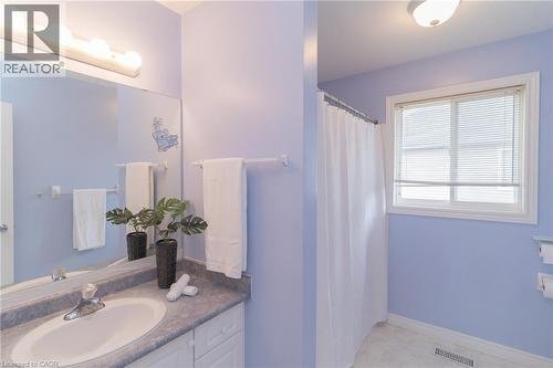 Bathroom featuring a single vanity with an oval sink, a large mirror, and overhead strip lighting - 566 Avignon Place, Waterloo, ON 