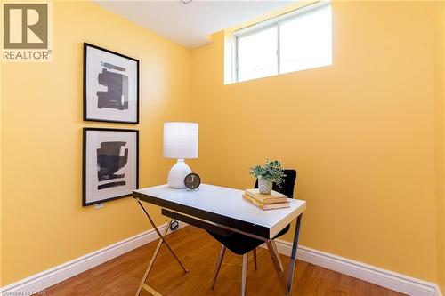 Compact room with a high-set window, warm-toned walls, wood-finish flooring, and crisp white baseboards - 566 Avignon Place, Waterloo, ON 