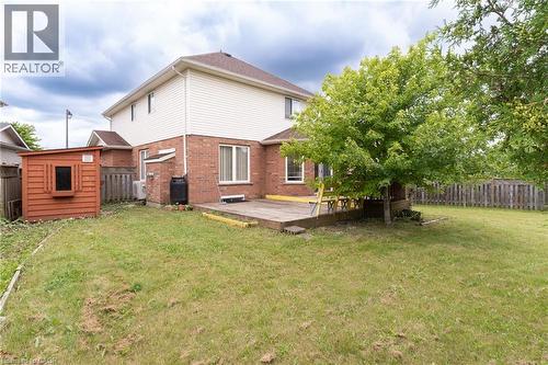 Spacious rear yard featuring a wooden deck, mature trees, and a storage shed - 566 Avignon Place, Waterloo, ON 