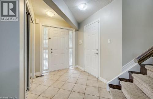 Entryway featuring a white paneled front door with sidelights, tile flooring, and a mirrored closet - 123 Forest Edge Trail, Kitchener, ON 