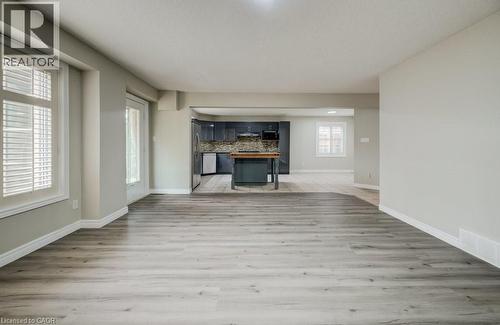 Spacious open-concept area featuring wide-plank wood-finish flooring and light gray wall paint - 123 Forest Edge Trail, Kitchener, ON - Indoor