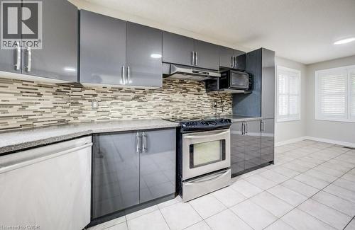 Kitchen featuring gray cabinetry with brushed nickel hardware, a mosaic tile backsplash, and light-toned tile flooring - 123 Forest Edge Trail, Kitchener, ON - Indoor Photo Showing Kitchen With Upgraded Kitchen