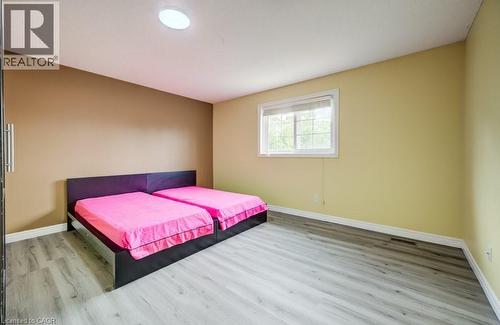 Room featuring wood-finish flooring, a window with white trim, a flush-mount ceiling light, and neutral-toned painted walls - 123 Forest Edge Trail, Kitchener, ON - Indoor Photo Showing Bedroom