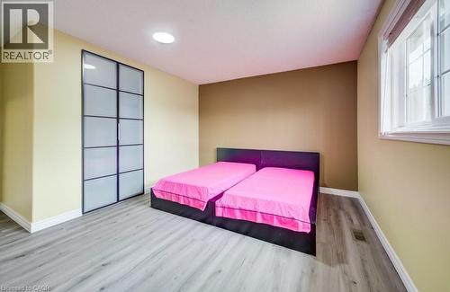 Bedroom featuring wood-finish flooring, a contemporary window, and a built-in closet with frosted glass panel doors - 123 Forest Edge Trail, Kitchener, ON - Indoor Photo Showing Bedroom