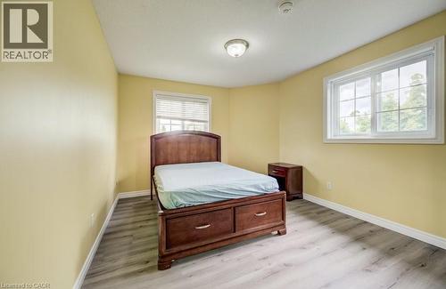 Bright room featuring two windows, light wood-finish flooring, white baseboards, and a semi-flush mount ceiling light - 123 Forest Edge Trail, Kitchener, ON - Indoor Photo Showing Bedroom