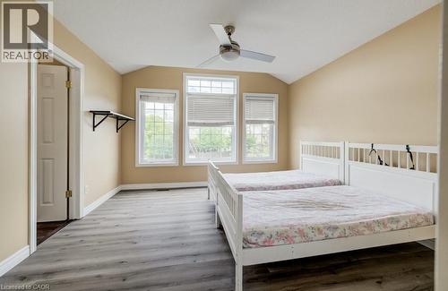 Room featuring wood-finish flooring, a vaulted ceiling, and three large windows - 123 Forest Edge Trail, Kitchener, ON - Indoor Photo Showing Bedroom