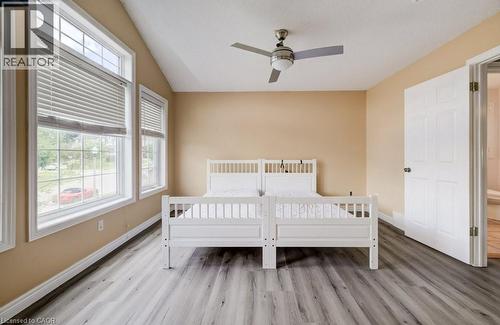 Room featuring vaulted ceilings, wood-finish flooring, multiple windows with blinds, a ceiling fan, and a six-panel interior door - 123 Forest Edge Trail, Kitchener, ON - Indoor Photo Showing Bedroom
