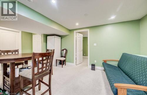 Carpeted recreation area featuring recessed lighting, a dropped ceiling with exposed beams, and a doorway leading to an additional space - 123 Forest Edge Trail, Kitchener, ON - Indoor