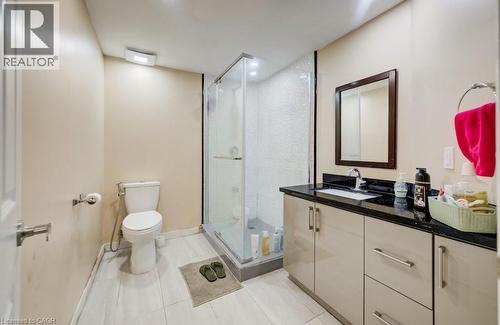 Bathroom featuring a glass-enclosed shower, a vanity with a dark countertop and light-toned cabinetry, and wood-finish flooring - 123 Forest Edge Trail, Kitchener, ON - Indoor Photo Showing Bathroom
