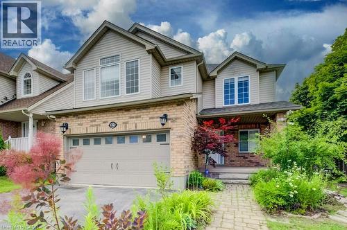 Traditional-style exterior featuring a brick and siding facade, an integrated two-car garage, multiple gables, a covered front porch, and a stone-paver walkway - 123 Forest Edge Trail, Kitchener, ON - Outdoor With Facade