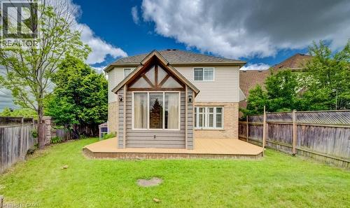 Expansive backyard featuring a large composite deck, sunroom addition with large windows, light brick and siding exterior, and a privacy fence - 123 Forest Edge Trail, Kitchener, ON - Outdoor