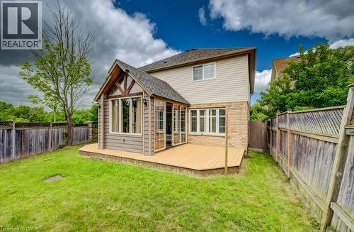 Expansive backyard featuring a large wooden deck, a sunroom extension with multiple windows, and natural wood fencing - 123 Forest Edge Trail, Kitchener, ON - Outdoor