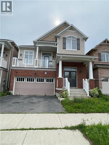 Two-story residential property featuring a brick and siding facade, an integrated two-car garage with window accents, and a covered main entrance - 235 Apple Hill Crescent, Kitchener, ON 