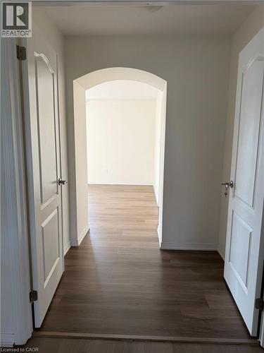 Inviting entryway featuring wood-finish flooring, an arched doorway, and light-colored walls - 235 Apple Hill Crescent, Kitchener, ON 