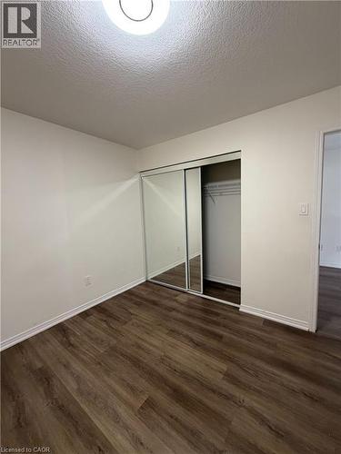 Interior room featuring wood-finish flooring, white walls, and white baseboards - 235 Apple Hill Crescent, Kitchener, ON 
