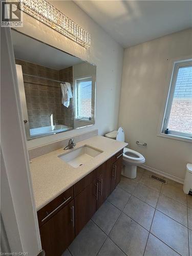 Bathroom featuring a vanity with dark wood-finish cabinetry, a light-toned countertop, and an undermount sink - 235 Apple Hill Crescent, Kitchener, ON 