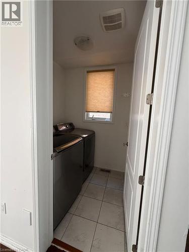 Laundry area featuring tile flooring, a window with blinds, and white walls - 235 Apple Hill Crescent, Kitchener, ON 