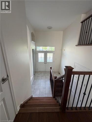 Entry foyer with double doors featuring decorative glass panels, tile flooring, and a soaring ceiling - 235 Apple Hill Crescent, Kitchener, ON 