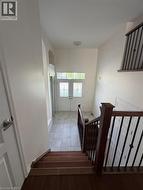 Entry foyer with double doors featuring decorative glass panels, tile flooring, and a soaring ceiling - 